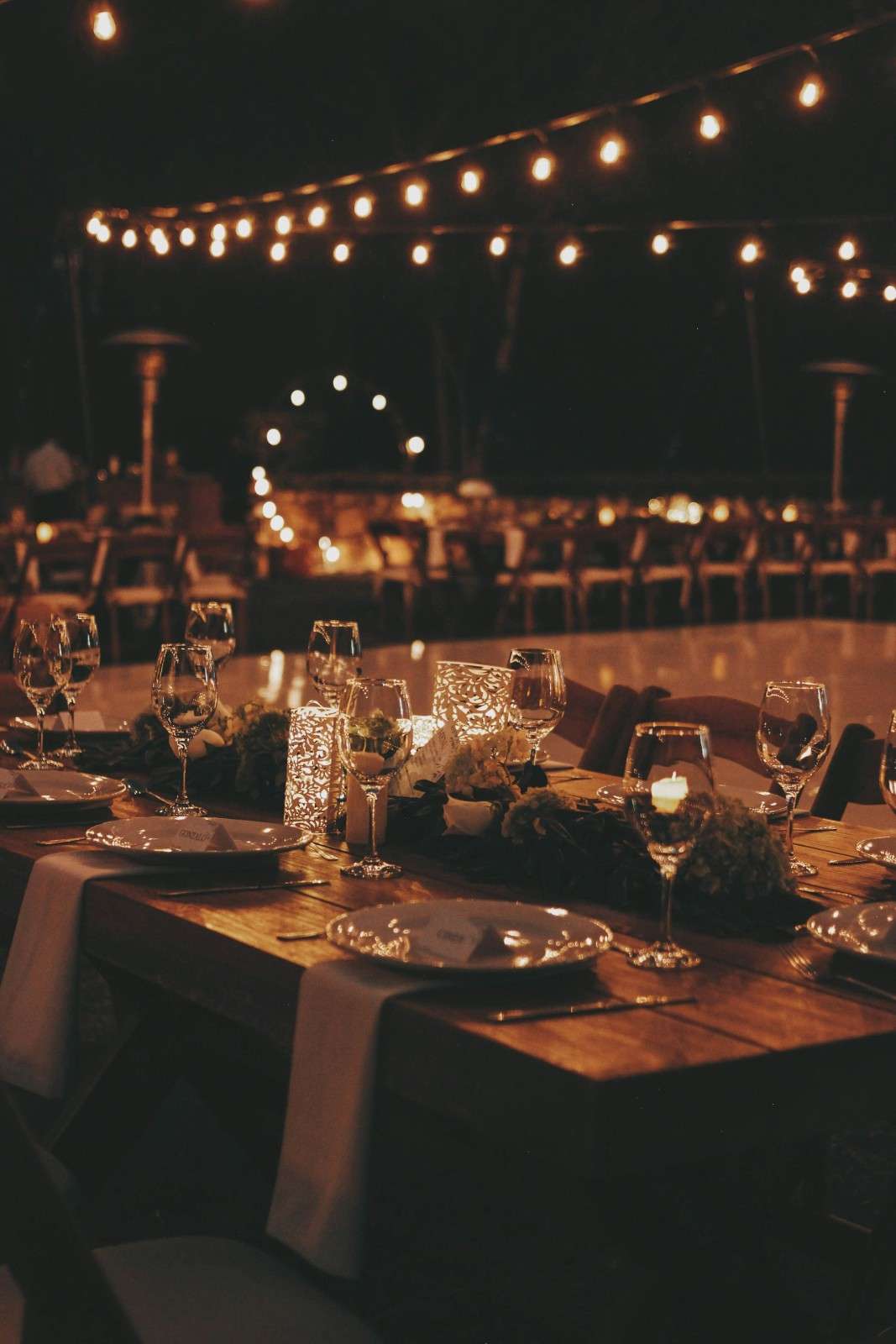 a table set for a formal dinner with candles and place settings