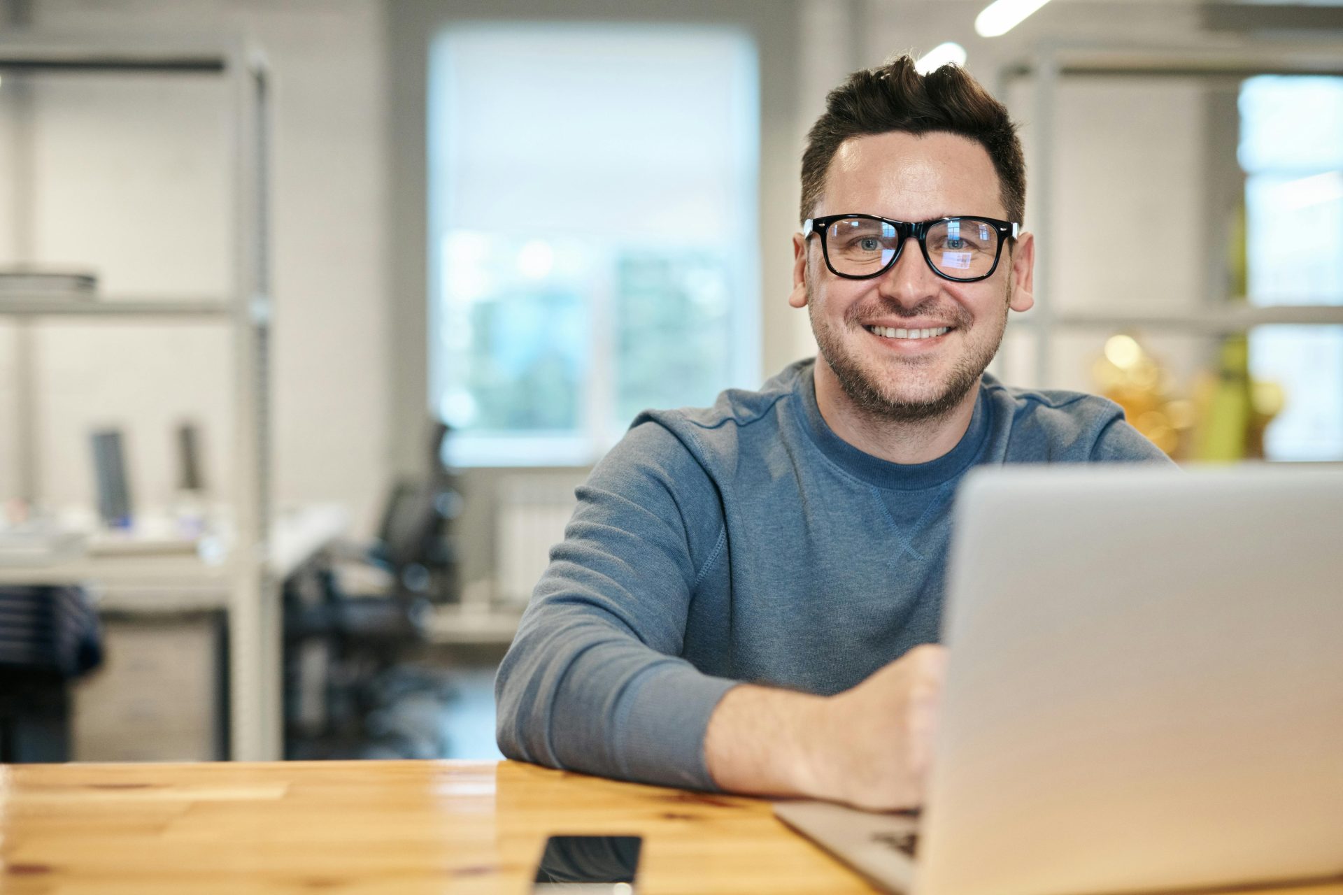 Hombre sonriendo frente a laptop