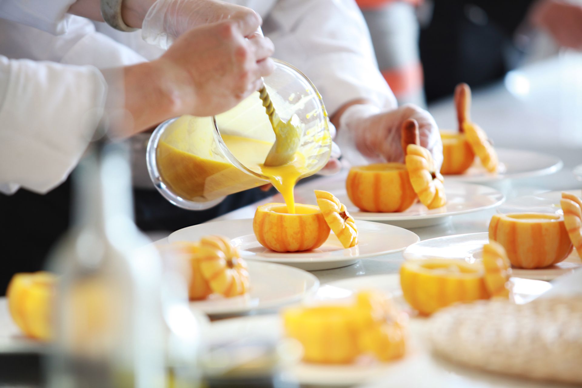 Chef sirviendo crema en calabazas